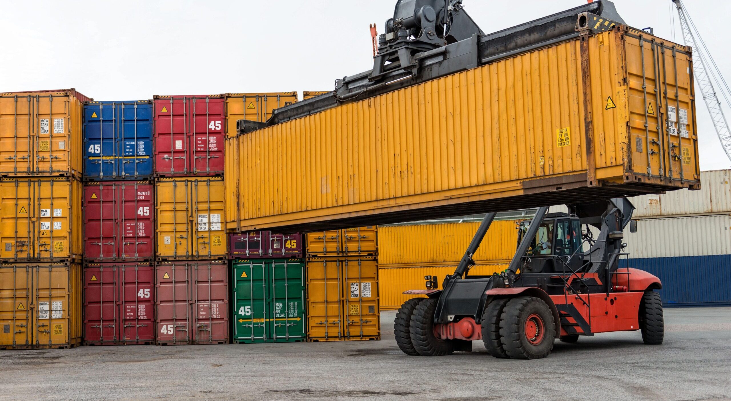Mobile stacker handler in action at a container terminal.